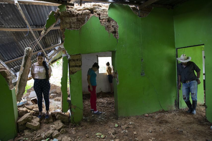 Miembros de una familia observan los destrozos causados por un deslizamiento provocado por los huracanes Eta y Iota en La Reina (Honduras) el 25 de junio del 2021.&nbsp;