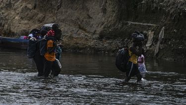 Los migrantes cruzan el río Chucunaque luego de caminar durante cinco días en el Darién Gap, en la aldea de Bajo Chiquito, provincia de Darién, Panamá el 10 de febrero de 2021.&nbsp; 