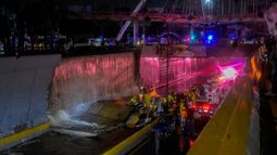 Los rescatistas buscan personas atrapadas debajo de un muro que se derrumbó sobre varios vehículos luego de fuertes lluvias en la avenida 27 de febrero de Santo Domingo, República Dominicana, el 18 de noviembre de 2023.