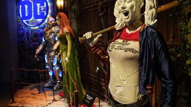 Un atuendo del personaje Harley Quinn, a la derecha, se exhibe en la exhibición interactiva Acción y magia hecha aquí durante una visita para la prensa de una gira por los Estudios Warner Bros.