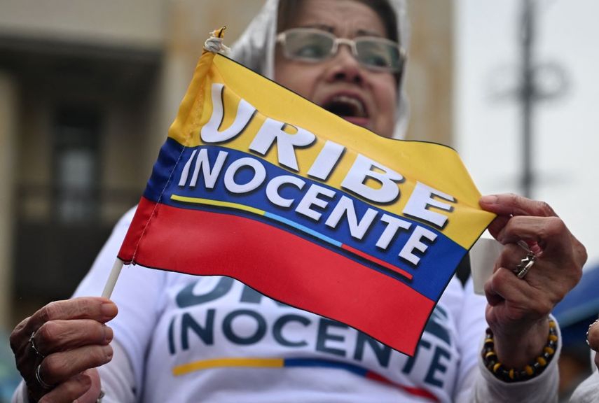 Una mujer sostiene una bandera colombiana mientras protesta en apoyo al expresidente colombiano Álvaro Uribe en Bogotá el 7 de agosto de 2025. Uribe, presidente de Colombia entre 2002 y 2010, fue condenado a 12 años de arresto domiciliario el 1 de agosto de 2025.