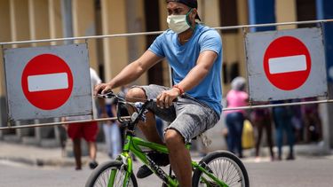 &nbsp; Un hombre con mascarilla viaja en bicicleta por una calle de La Habana.