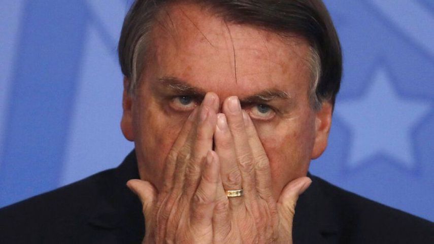 El presidente brasileño Jair Bolsonaro se pone las manos en el rostro durante una ceremonia en el palacio presidencial en Brasilia el jueves, 26 de noviembre del 2020.&nbsp; &nbsp;