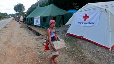 Una mujer lleva una caja de donaciones en un campamento de la Cruz Roja Cubana cerca del pueblo de San Antonio del Sur, provincia de Guantánamo, Cuba, el 30 de octubre de 2024, días después del paso del huracán Oscar.