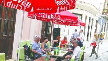 Tursitas extranjeros consumen cervezas en una terraza de la zona colonial de La Habana.