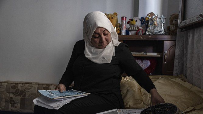 Hamrin Alouji, madre de Peyal Aqil, de 13 años, revisa las fotos de su hija en su casa en Qamishli, Siria, el 5 de junio de 2023.