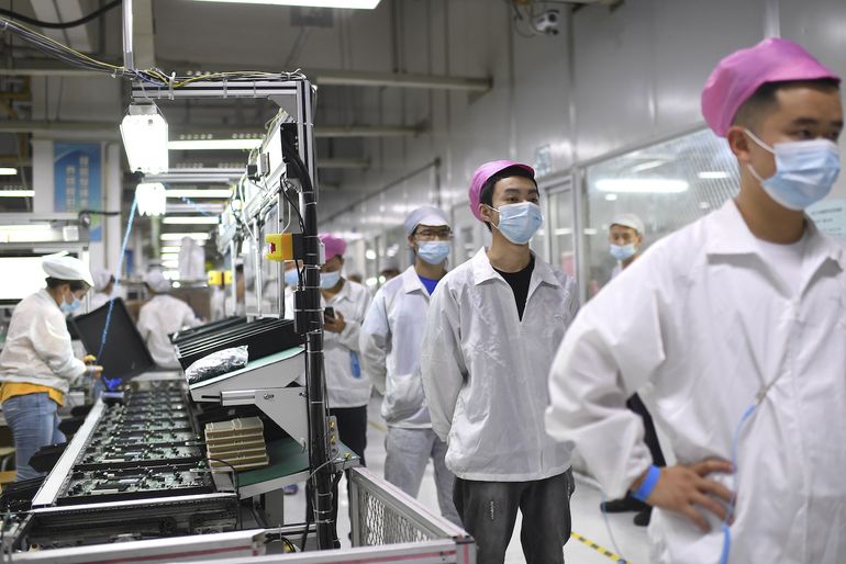 Empleados se forman para someterse a una prueba de coronavirus en una fábrica de Wuhan, China, el 5 de agosto de 2021. 