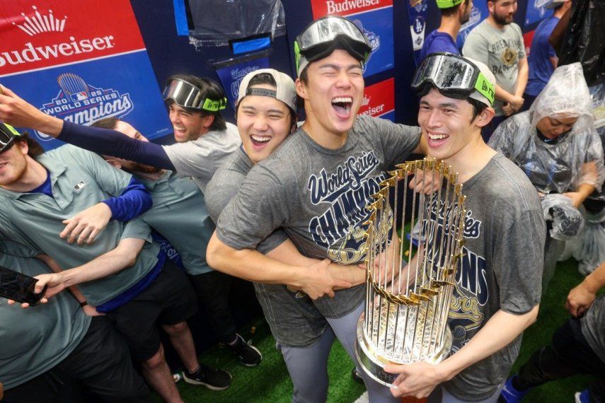 Shohei Ohtani (#17), Yoshinobu Yamamoto (#18) y Roki Sasaki (#11), de los Dodgers de Los Ángeles, celebran en el vestuario tras derrotar a los Azulejos de Toronto 5-4 en el séptimo juego y ganar la Serie Mundial de 2025 en el Rogers Center el 2 de noviembre de 2025 en Toronto, Ontario.