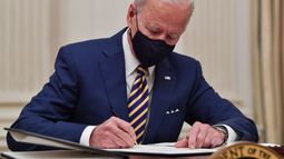 El presidente Joe Biden firma órdenes ejecutivas en la Casa Blanca.