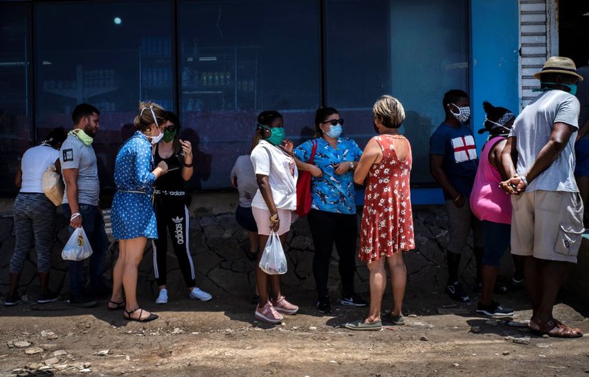 Afuera de una tienda estatal de comida, personas con mascarillas para protegerse del nuevo coronavirus esperan en línea para entrar en La Habana, Cuba, el martes 19 de mayo de 2020.&nbsp;