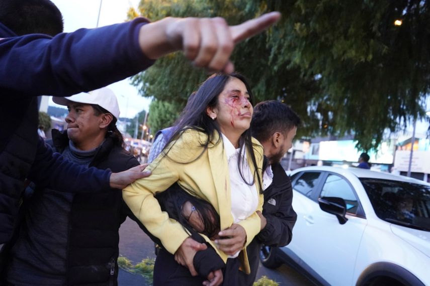 Una mujer herida es apartada de la escena donde fue asesinado a tiros el candidato presidencial Fernando Villavicencio en un mitin en una escuela en Quito, Ecuador, el 9 de agosto de 2023.