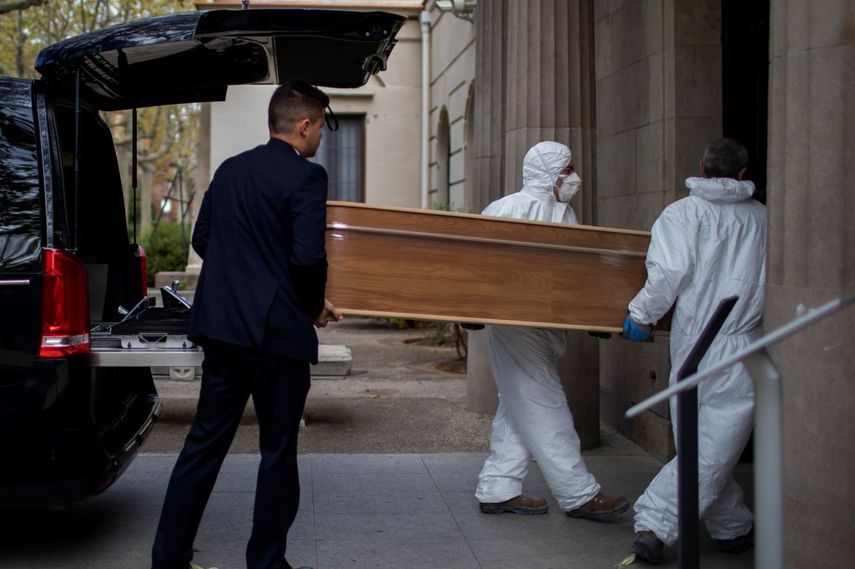 Empleados de una funeraria trasladan un ata&uacute;d para un entierro en un cementerio en Barcelona durante el brote del coronavirus en Espa&ntilde;a, el viernes 27 de marzo de 2020.