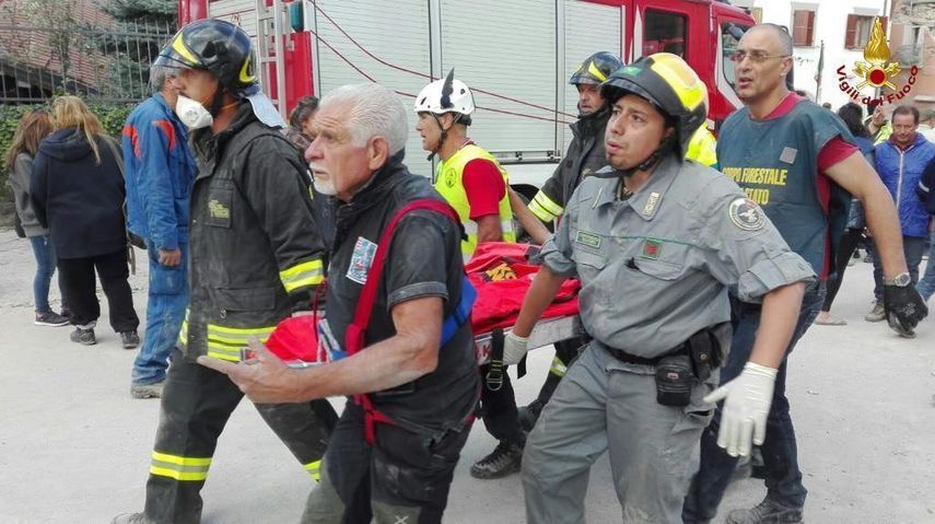 &nbsp;Varios bomberos trasladan una camilla en Amatrice, en el centro de Italia