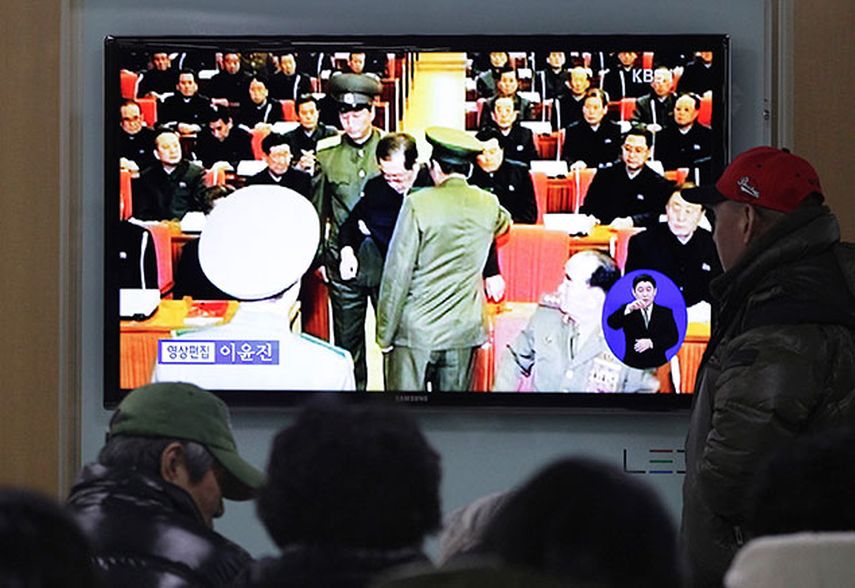 Varias personas observan un televisor en una estación ferroviaria en Seúl, Corea del Sur, que transmite el momento en que dos policías arrestan a Jang Song Thaek, (al centro, tío del líder norcoreano Kim Jong Un), durante una reunión de emergencia del