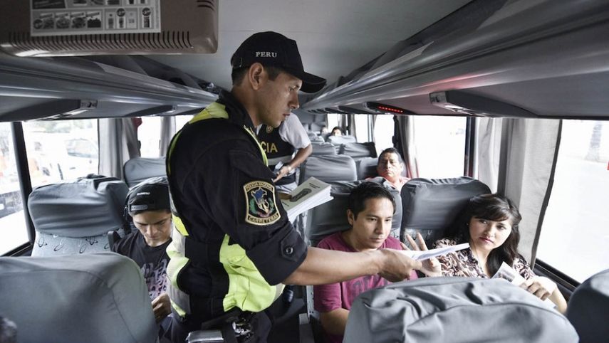 Un oficial de Policía revisa documentos de pasajeros en un ómnibus en Perú.