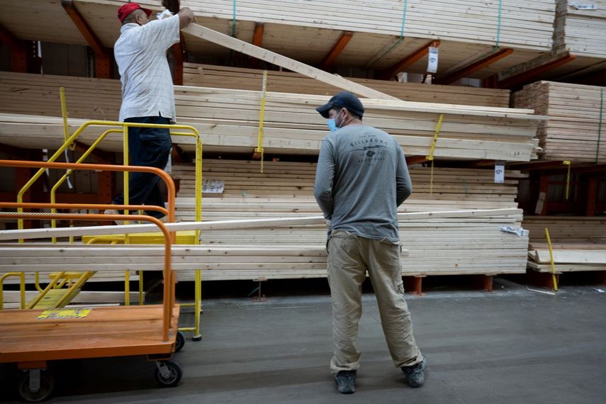 Clientes compran madera una tienda de Home Depot.