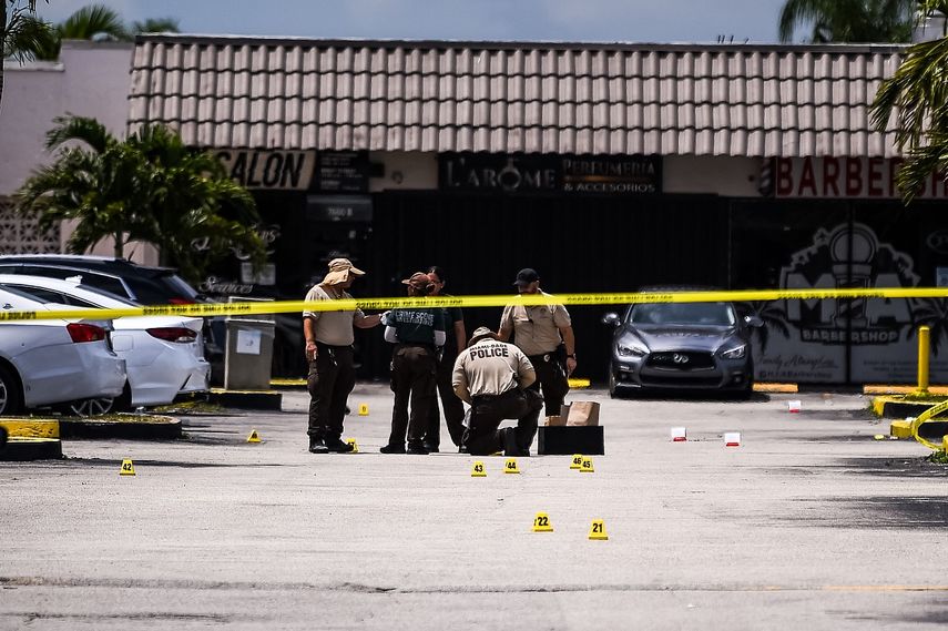 Agentes de policía de Miami Dade recolectan evidencia en el estacionamiento frente a un club de billar que fue alquilado para un concierto, luego de que tres hombres armados mataron a dos personas e hirieron a 20 durante la noche en el&nbsp; condado de Miami Dade el 30 de mayo de 2021.&nbsp;&nbsp;