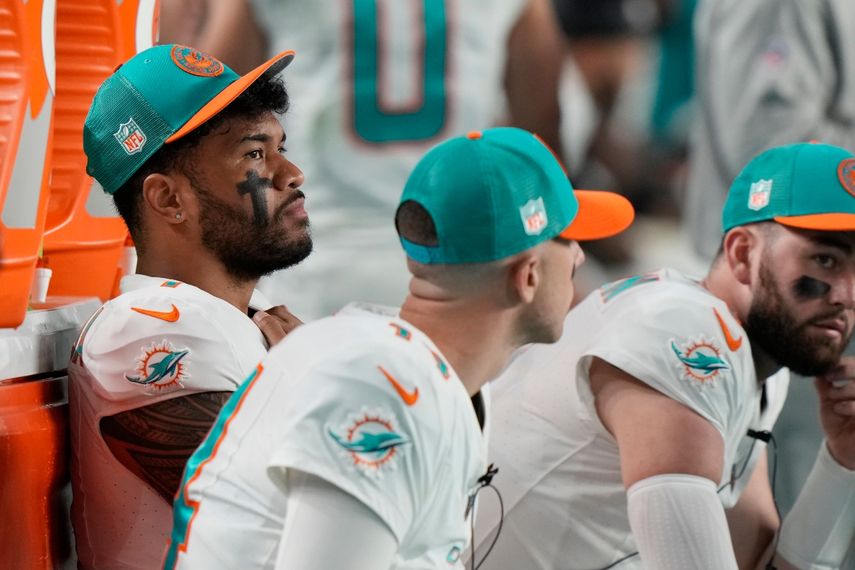 El mariscal de campo de los Dolphins, Tua Tagovailoa (izquierda), se sienta al margen durante la segunda mitad de un partido de fútbol americano de la NFL contra los Bills, el domingo 7 de enero de 2024, en Miami Gardens, Florida.