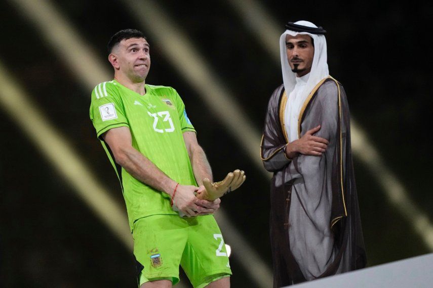 El arquero argentino Emiliano Martínez hace un gesto después de recibir el guante de oro al mejor arquero después del partido de fútbol final de la Copa del Mundo entre Argentina y Francia en el Estadio Lusail en Lusail, Catar, el domingo 18 de diciembre de 2022. Argentina ganó 4-2 en una tanda de penaltis después de que el partido terminara empatado 3-3.&nbsp;