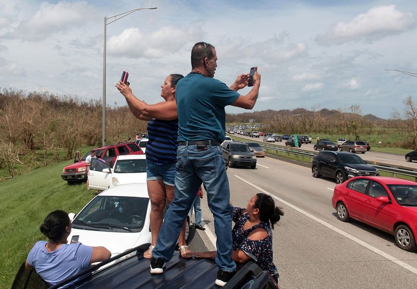Se espera que al menos 100.000 desplazados lleguen al estado de Florida. En la imagen, varios ciudadanos puertorriqueños tratan de acceder a lugares con cobertura móvil para comunicarse con sus familiares y amigos.