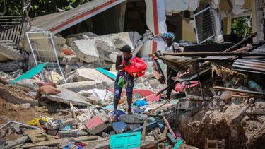 Unas mujeres recuperan sus pertenencias de sus casas destrozadas el domingo 15 de agosto de 2021, en Les Cayes, Haití, luego de un sismo de magnitud 7,2.&nbsp;