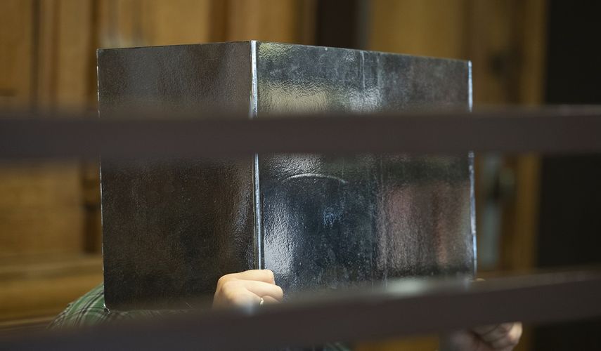 El acusado en un supuesto caso de canibalismo se cubre la cara con un cartón en la primera sesión de su juicio en Berlín, el 10 de agosto de 2021.&nbsp;