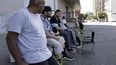 William Nonluecha (en primer plano) y sus amigos se sientan en una zona de sombra, el 27 de julio de 2022, en Portland, Oregon, en plena ola de calor en el noroeste de la costa estadounidense del Pacífico.&nbsp;