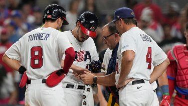Nolan Arenado, de Estados Unidos, es revisado por un asistente del equipo después de recibir un pelotazo en la mano por un lanzamiento en la quinta entrada del partido del Clásico Mundial de béisbol entre Estados Unidos y Cuba, el domingo 19 de marzo de 2023, en Miami.&nbsp;