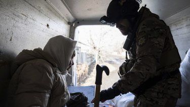 Un policía ucraniano ayuda a una anciana mientras evacua a áreas seguras en Chasiv Yar, cerca de Bájmut, Ucrania, el sábado 4 de marzo de 2023.&nbsp;