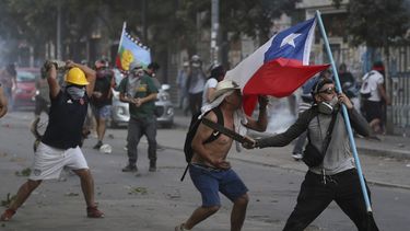 Manifestantes chocan con la policía en Santiago de Chile el viernes, 20 de diciembre del 2019. El presidente Sebastián Piñera promulgó el lunes una ley que permitirá la realización en abril de un plebiscito en el que los chilenos decidirán si cambian la Constitución heredada de la dictadura militar en medio del mayor estallido social en tiempos de democracia en el país sudamericano.