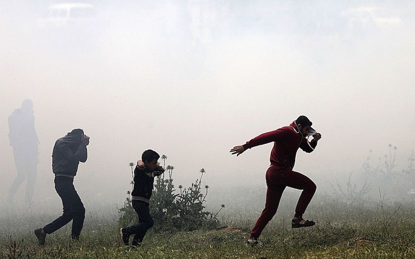 Varios palestinos huyen de gases lacrimógenos durante los enfrentamientos con soldados israelíes en el este de Beit Hanun, norte de la&nbsp;Franja&nbsp;de&nbsp;Gaza.&nbsp;