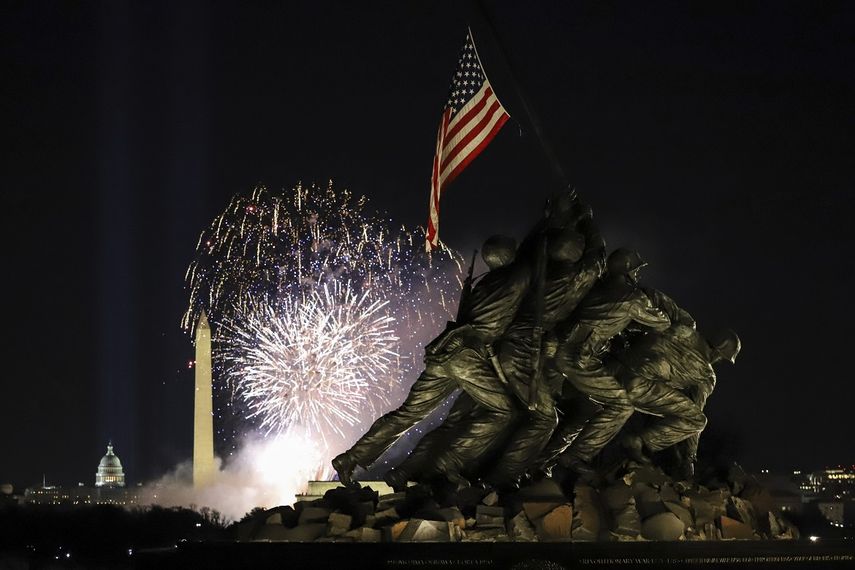 Fuegos artificiales ilumninan la noche sobre el Monumento a Washington, con el Monumento a los Infantes de Marina al frente, en Washington DC.