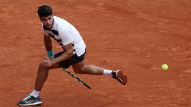 El español Carlos Alcaraz devuelve un golpe de derecha al italiano Giulio Zeppieri durante su partido en el segundo día del torneo de tenis Abierto de Francia en la cancha Suzanne-Lenglen en el Complejo Roland-Garros en París, el 26 de mayo de 2025.