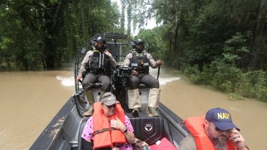 Guardias del Departamento de Parques y Vida Silvestre de Texas, utilizan un bote para rescatar a residentes de las inundaciones en el condado Liberty, Texas, el sábado 4 de mayo de 2024.