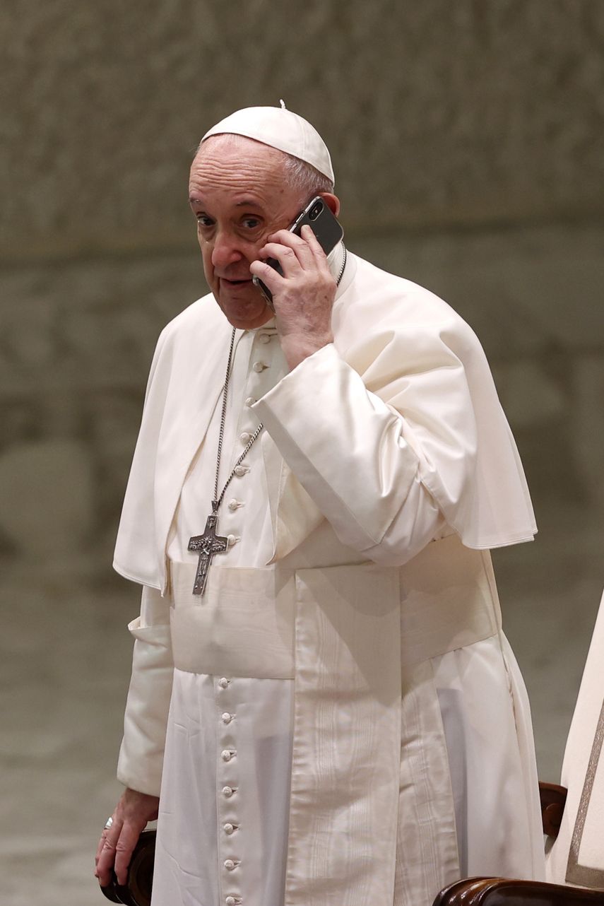 El papa Francisco habla por un teléfono celular que le entregó su asistente Piergiorgio Zanetti, al cabo de la audiencia general semanal en la Sala Paulo VI en el Vaticano, miércoles 11 de agosto de 2021.&nbsp;