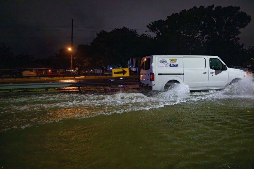 El canal de drenaje W. Napoleon Ave, tras una barandilla, se ve casi a la misma altura que la calle, cubierta por una inundación.&nbsp;