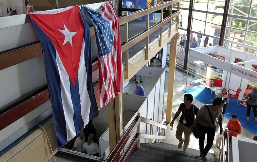 Dos hombres caminan frente a las banderas de EEUU y Cuba en La Habana (Cuba) (EFE)