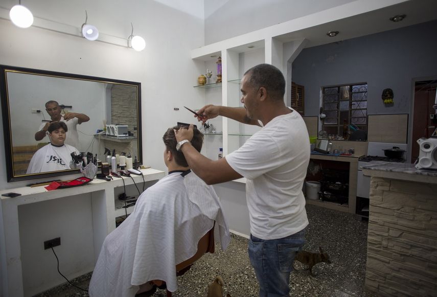 El barbero Yacel Shang corta el cabello a un cliente en su barbería instalada en su casa en La Habana, Cuba, el sábado 11 de enero de 2020.&nbsp;