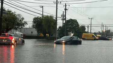 Un auto queda atrapado en una calle inundada, debido a las fuertes lluvias en Florida.