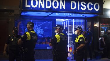 Polic&iacute;as con mascarillas vigilan mientras personas caminan en la calle en Fuengirola, cerca de M&aacute;laga, Espa&ntilde;a, el s&aacute;bado 8 de agosto de 2020.&nbsp;