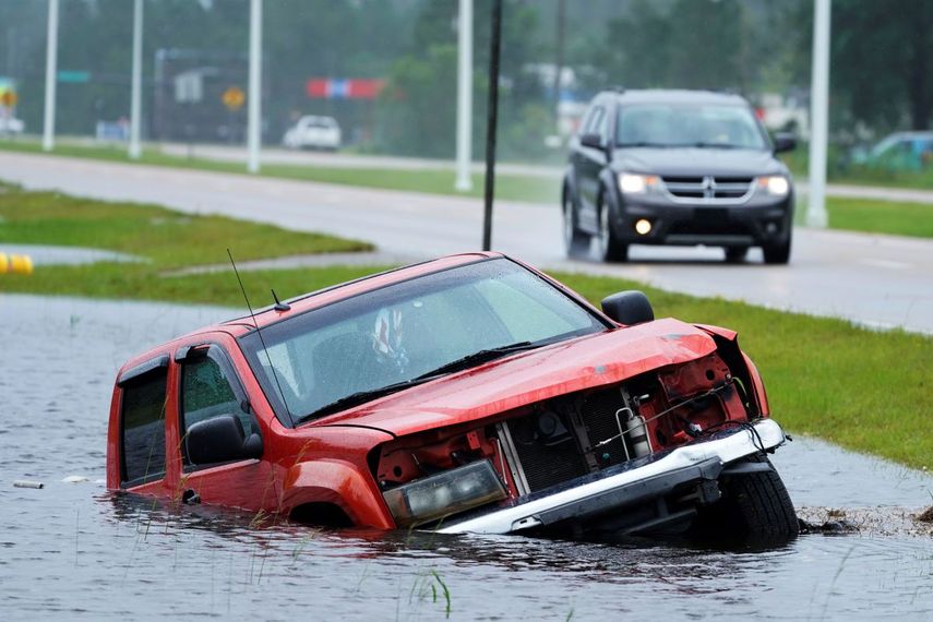 Un vehículo abandonado se ve medio sumergido en una cuneta junto a una autopista casi inundada, bajo los aguaceros del huracán Ida el domingo 29 de agosto de 2021, en Bay Sain Louis, Mississippi.&nbsp;