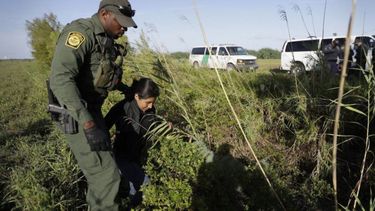 Un agente de Aduanas y Protección Fronteriza detiene a una persona inmigrante que cruzó ilegalmente hacia Estados Unidos por el Rio Grande (río Bravo para México) cerca de Granjeno, Texas.&nbsp;