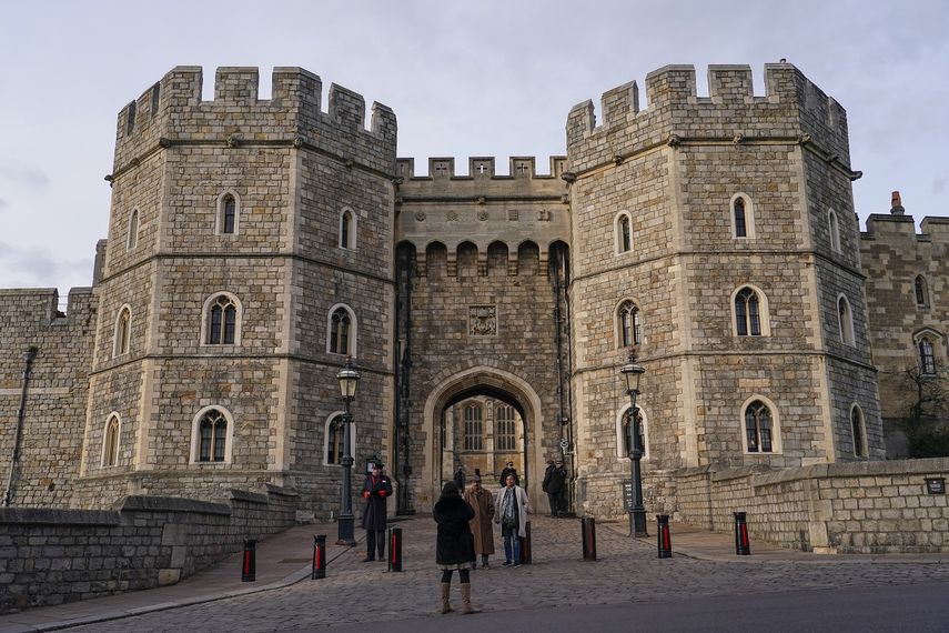 En esta imagen de archivo, un grupo de personas se toma una foto mientras la policía custodia la entrada al Castillo de Windsor, en Windsor, cerca de Londres, el 11 de febrero de 2022.&nbsp;