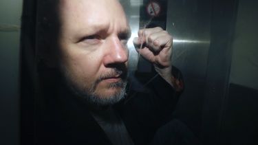 El fundador de WikiLeaks, Julian Assange, es conducido fuera de la corte en la que compareció acusado de incumplir las condiciones de su libertad bajo fianza hace siete años, en Londres, el miércoles 1 de mayo de 2019. 