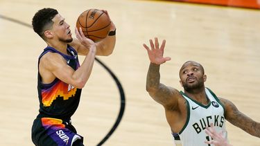El escolta de los Suns de Phoenix, Devin Booker, dispara ante la defensiva del alero de los Bucks de Milwaukee, P.J. Tucker, en la segunda mitad del segundo juego de las Finales de la NBA