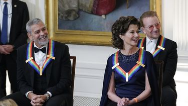 De izquierda a derecha, George Clooney, Amy Grant y Bono escuchan mientras el presidente Joe Biden habla en la recepción para los homenajeados del Centro Kennedy, el domingo 4 de diciembre de 2022, en la Casa Blanca en Washington.