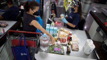 Una mujer pasa por la caja en un supermercado de Caracas. Ya no hay escasez de productos en los supermercados de Venezuela, pero no mucha gente puede pagar los altos precios que se cobran, sobre todo si no tienen dólares y dependen del devaluado bolívar, la divisa nacional.