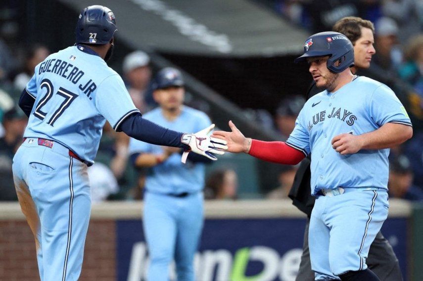 Vladimir Guerrero Jr. #27 y Alejandro Kirk #30 de los Toronto Blue Jays celebran tras anotar carreras durante la tercera entrada contra los Seattle Mariners en el tercer juego de la Serie de Campeonato de la Liga Americana en el T-Mobile Park el 15 de octubre de 2025 en Seattle, Washington.&nbsp;