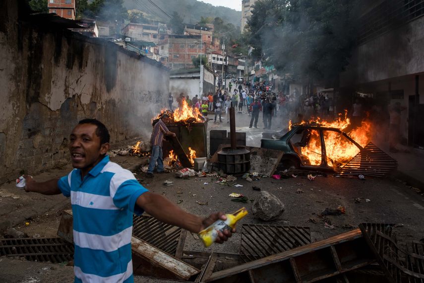 Un grupo de personas se manifiestan en una calle en las inmediaciones de un comando de la Guardia Nacional Bolivariana este lunes, en Carcas (Venezuela).