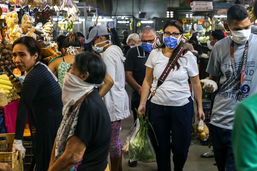 &nbsp; &nbsp; Venezolanos visitan un mercado mientras usan mascarillas protectoras para evitar la propagaci&oacute;n del nuevo coronavirus, en Caracas, el 15 de marzo de 2020.